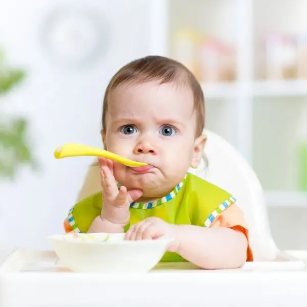 Mama sandalyesinde yemek yiyen bebek